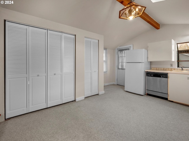 kitchen with white cabinets, light carpet, stainless steel dishwasher, vaulted ceiling with skylight, and white fridge