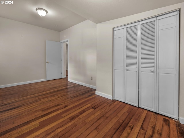 unfurnished bedroom featuring dark wood-type flooring and a closet