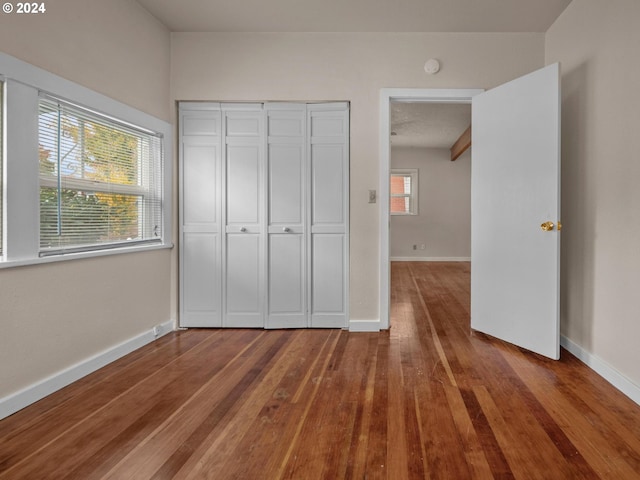 unfurnished bedroom with hardwood / wood-style floors and a closet