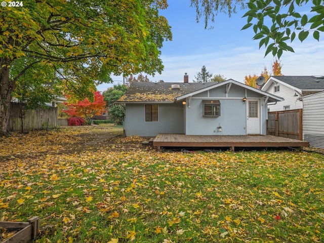 back of property featuring a lawn and a wooden deck