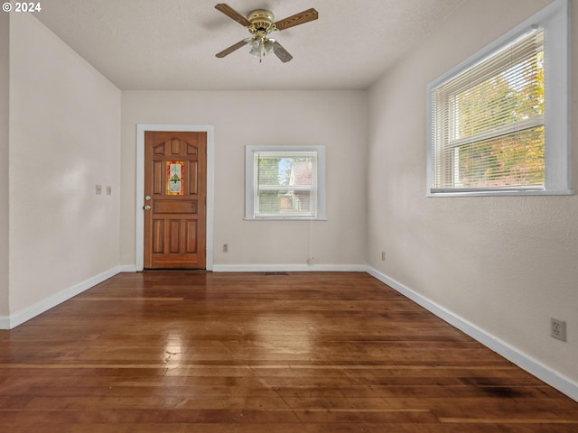 unfurnished room with dark wood-type flooring and ceiling fan