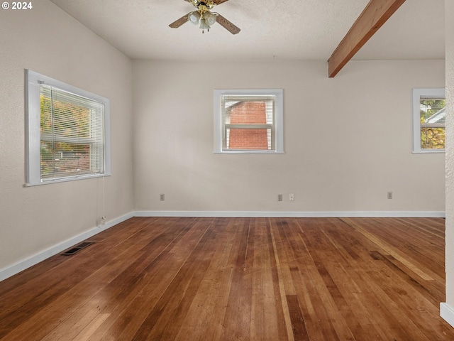 unfurnished room with ceiling fan, hardwood / wood-style flooring, beamed ceiling, and a textured ceiling