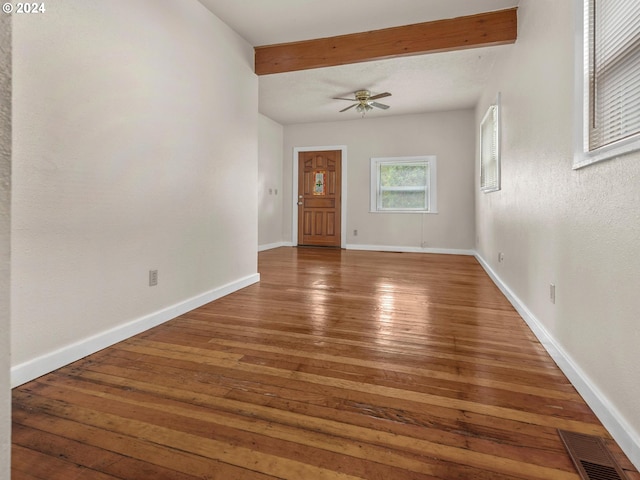 unfurnished room featuring dark wood-type flooring, ceiling fan, and beam ceiling