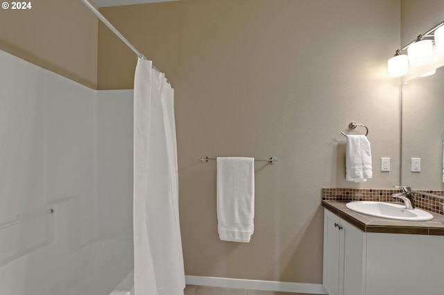 bathroom with decorative backsplash, vanity, and tile patterned flooring