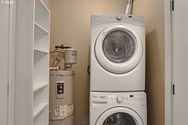 clothes washing area with strapped water heater and stacked washer and clothes dryer