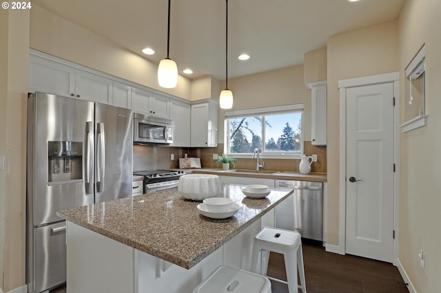 kitchen featuring white cabinets, sink, decorative backsplash, light stone counters, and stainless steel appliances