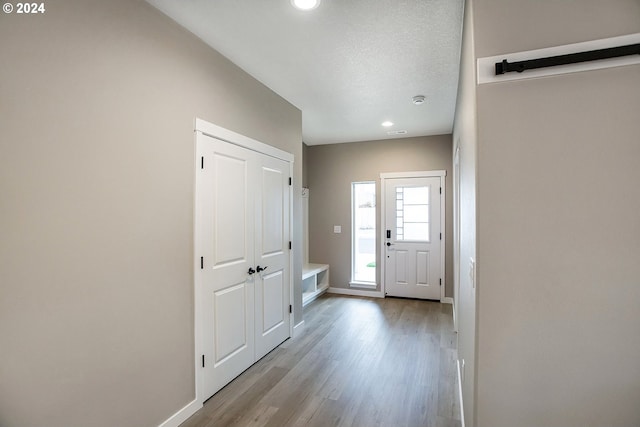 entrance foyer featuring a textured ceiling, recessed lighting, wood finished floors, and baseboards