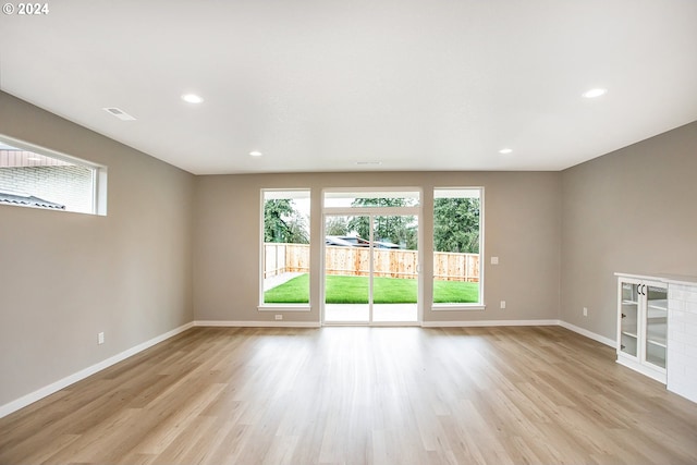 unfurnished living room featuring light wood-type flooring, baseboards, and visible vents