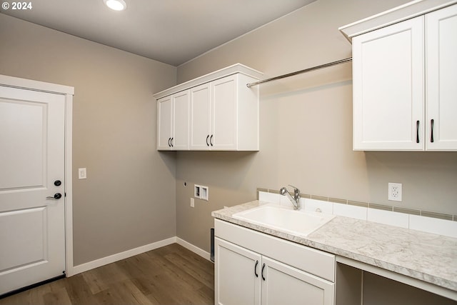 washroom with cabinet space, baseboards, dark wood finished floors, washer hookup, and a sink