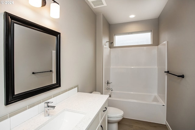 bathroom with shower / bath combination, visible vents, toilet, vanity, and wood finished floors