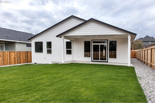 rear view of property featuring crawl space, a lawn, and a fenced backyard