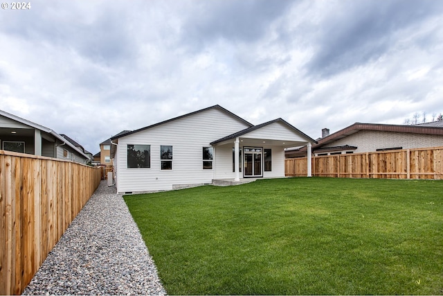 rear view of house featuring a yard, crawl space, a patio, and a fenced backyard