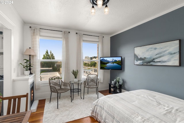 bedroom with wood-type flooring, multiple windows, and a textured ceiling