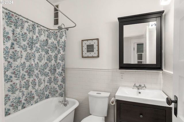 bathroom with vanity, a tub, tile walls, and toilet