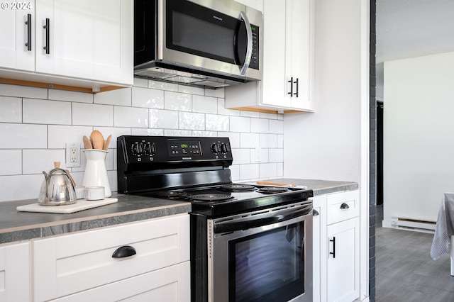 kitchen with white cabinetry, dark wood-type flooring, a baseboard radiator, black electric range oven, and decorative backsplash