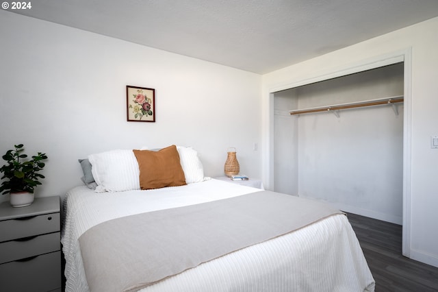 bedroom with dark wood-type flooring and a closet