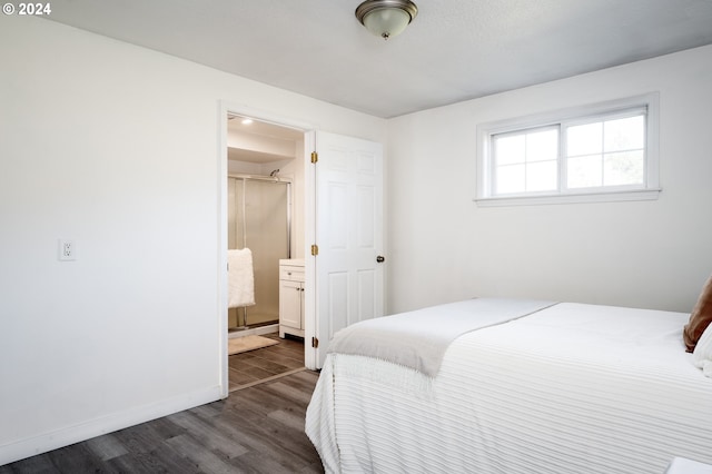 bedroom with dark hardwood / wood-style floors and ensuite bathroom