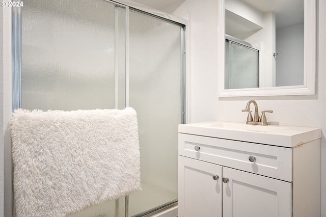 bathroom with vanity and a shower with shower door