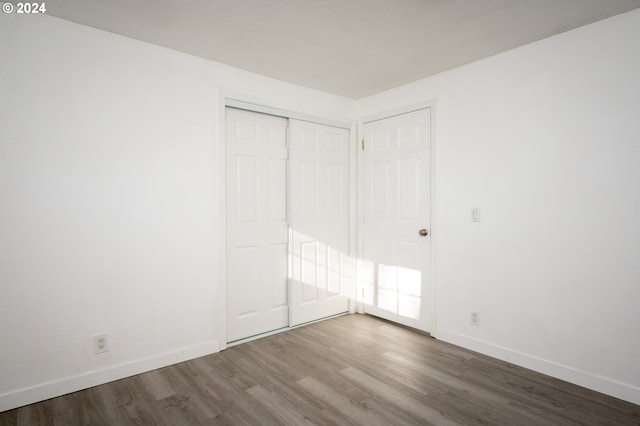 unfurnished bedroom with hardwood / wood-style floors and a closet