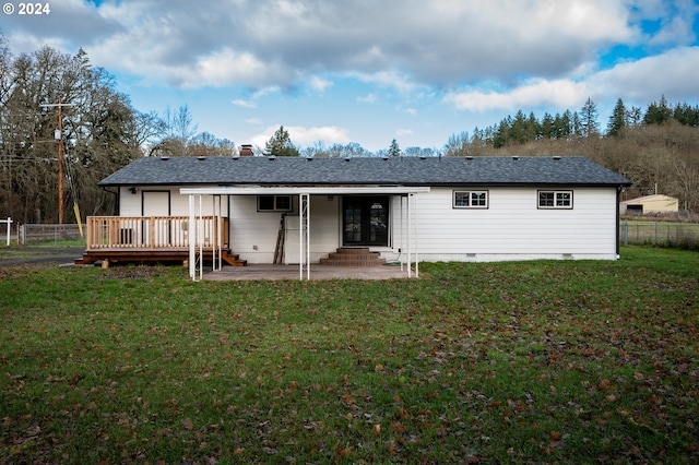 rear view of house with a wooden deck, a patio area, and a lawn