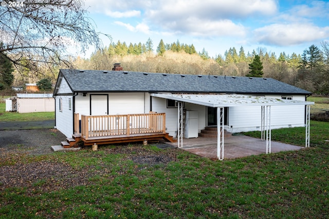 back of property featuring a lawn, a patio, and a wooden deck