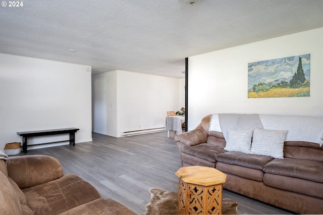 living room with a textured ceiling, dark hardwood / wood-style flooring, and a baseboard heating unit