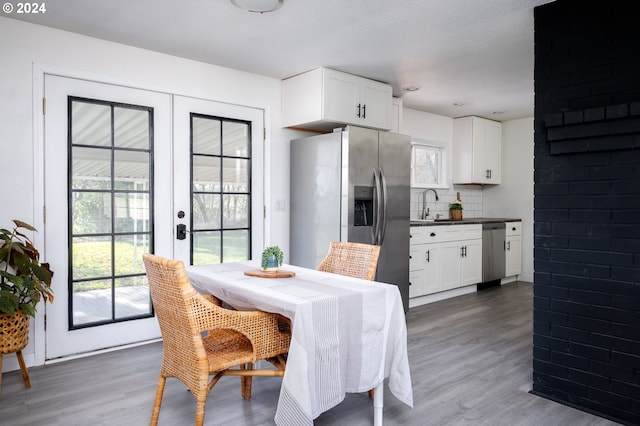 dining room with a textured ceiling, dark hardwood / wood-style floors, sink, and french doors