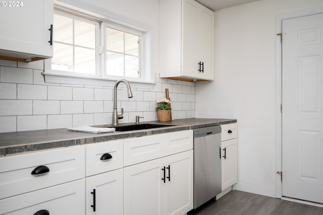 kitchen featuring dark hardwood / wood-style flooring, tasteful backsplash, stainless steel dishwasher, sink, and white cabinets