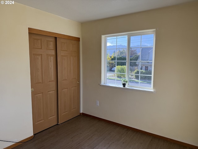 9845 N Lombard St, Portland, OR 97203 - unfurnished bedroom featuring wood finished floors, a closet, and baseboards
