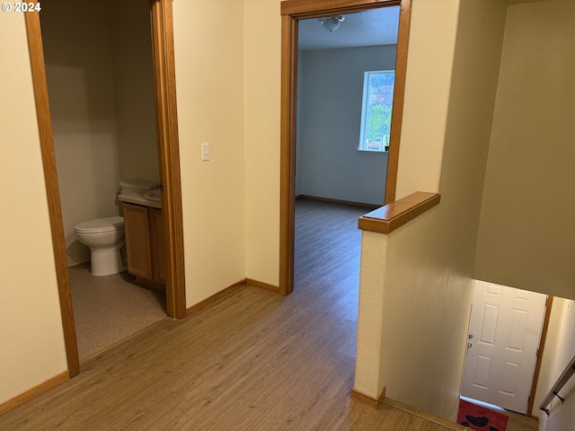 9845 N Lombard St, Portland, OR 97203 - hallway with light wood finished floors, baseboards, and an upstairs landing