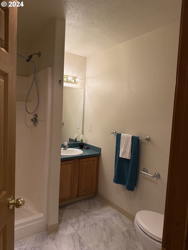 9845 N Lombard St, Portland, OR 97203 - bathroom featuring a stall shower, marble look tile flooring, vanity, toilet, and baseboards
