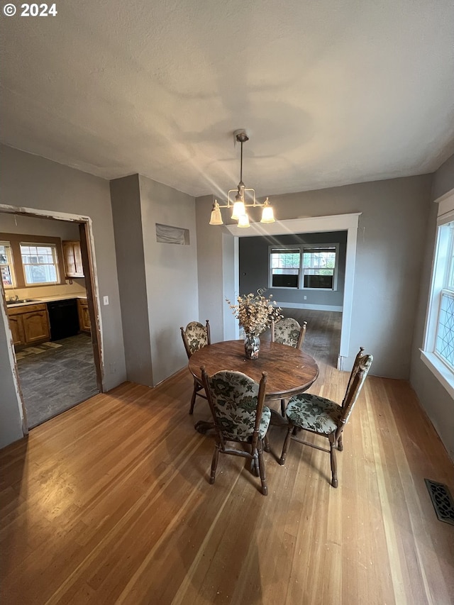 dining room with light wood-style flooring, visible vents, and an inviting chandelier