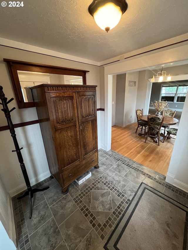 interior space with a chandelier, dark wood finished floors, and a textured ceiling