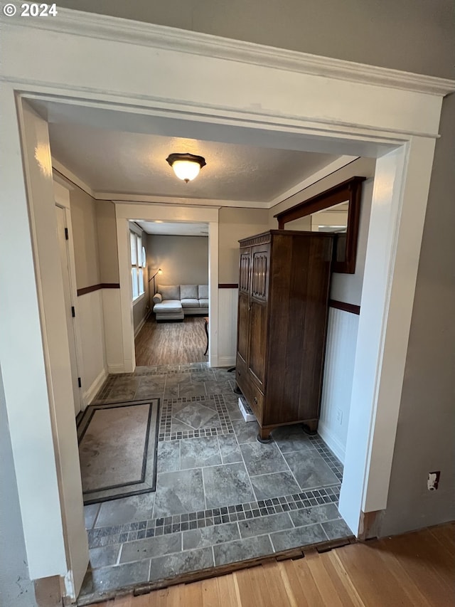 hallway featuring dark wood-type flooring and crown molding