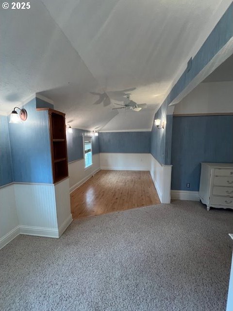 additional living space featuring vaulted ceiling, ceiling fan, carpet, and wood finished floors