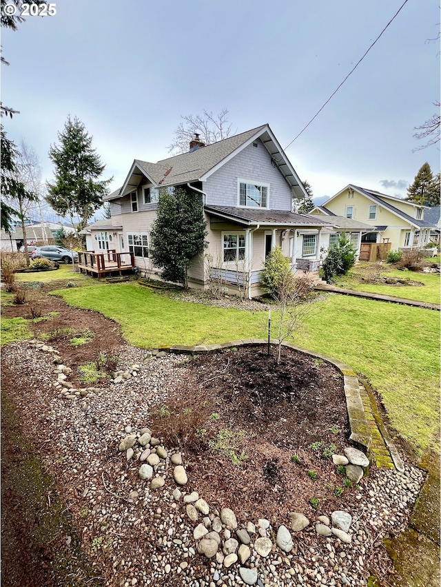 exterior space featuring a deck, a lawn, and a chimney