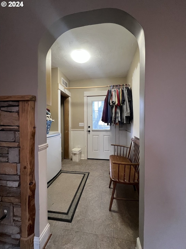 mudroom with arched walkways, washer / dryer, a textured ceiling, and visible vents