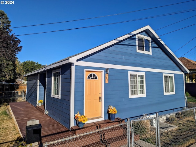 bungalow-style home featuring a deck, fence private yard, and a gate