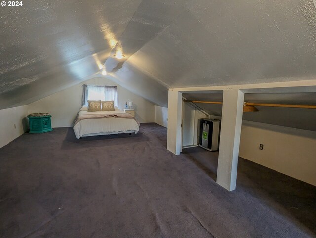 unfurnished bedroom with a textured ceiling, lofted ceiling, and dark carpet