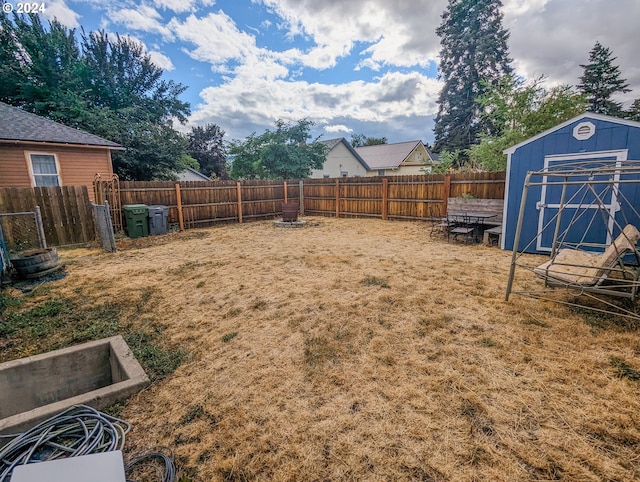 view of yard with an outbuilding, a shed, and a fenced backyard