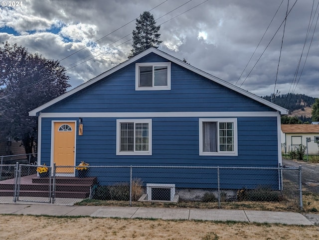 bungalow-style house featuring a gate and fence