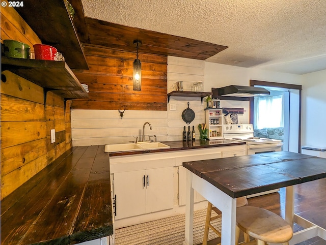 kitchen with open shelves, a sink, under cabinet range hood, dark countertops, and white range with electric stovetop