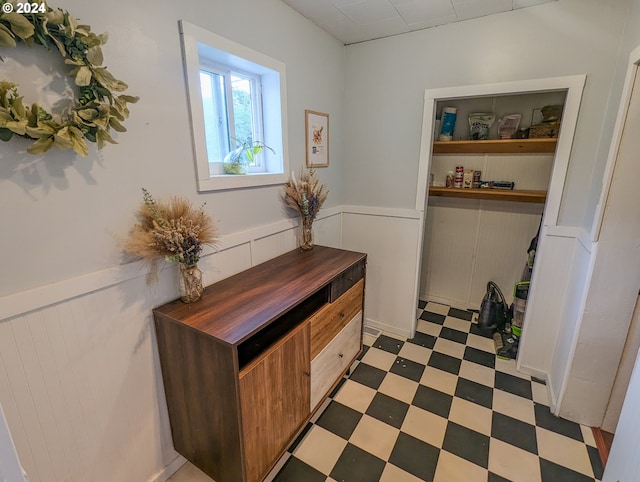 hallway with a wainscoted wall and light floors