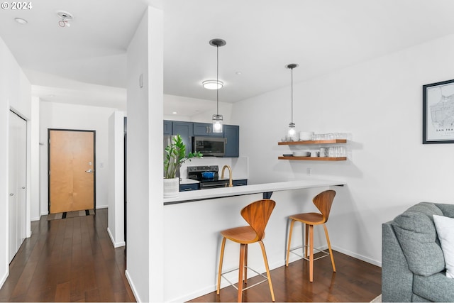 kitchen with appliances with stainless steel finishes, kitchen peninsula, a kitchen breakfast bar, decorative light fixtures, and dark wood-type flooring