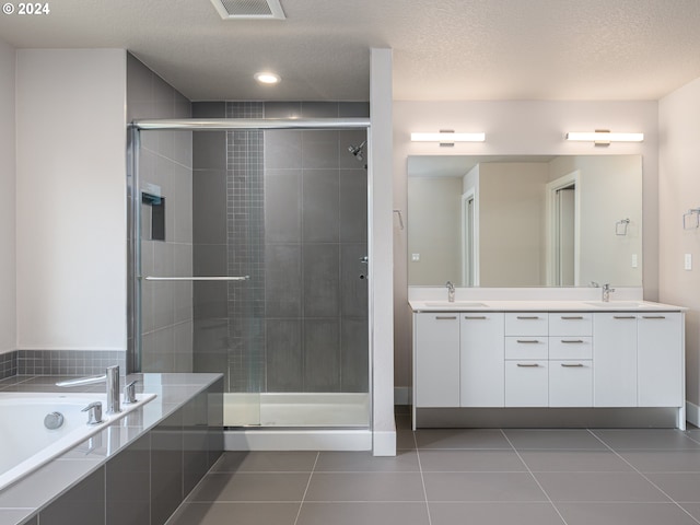 bathroom featuring tile patterned flooring, vanity, a textured ceiling, and separate shower and tub