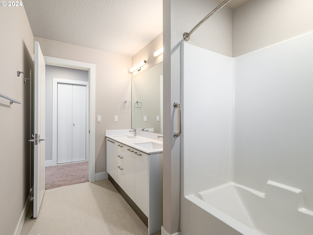 bathroom featuring vanity, washtub / shower combination, and a textured ceiling