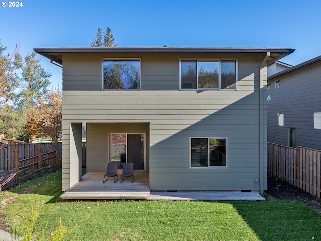 back of property featuring a yard and a deck