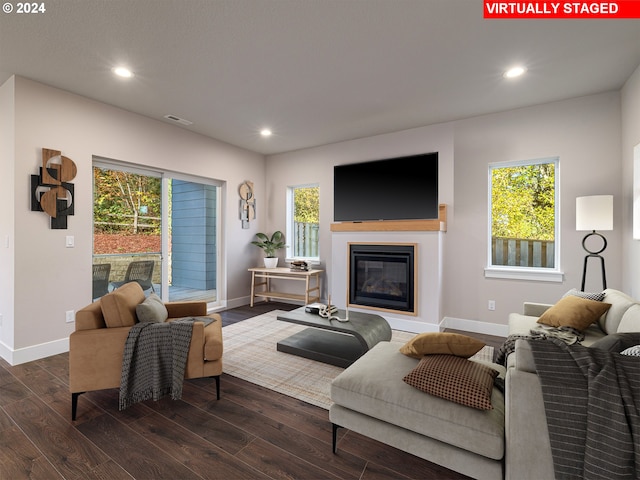 living room with a healthy amount of sunlight and dark wood-type flooring