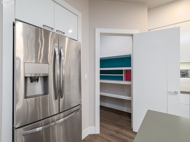 kitchen with dark wood-type flooring, white cabinets, and stainless steel refrigerator with ice dispenser