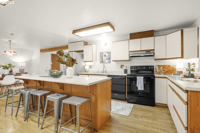 2626 NW 83rd Pl, Portland, OR 97229 - kitchen featuring black appliances, under cabinet range hood, a sink, light wood finished floors, and light countertops
